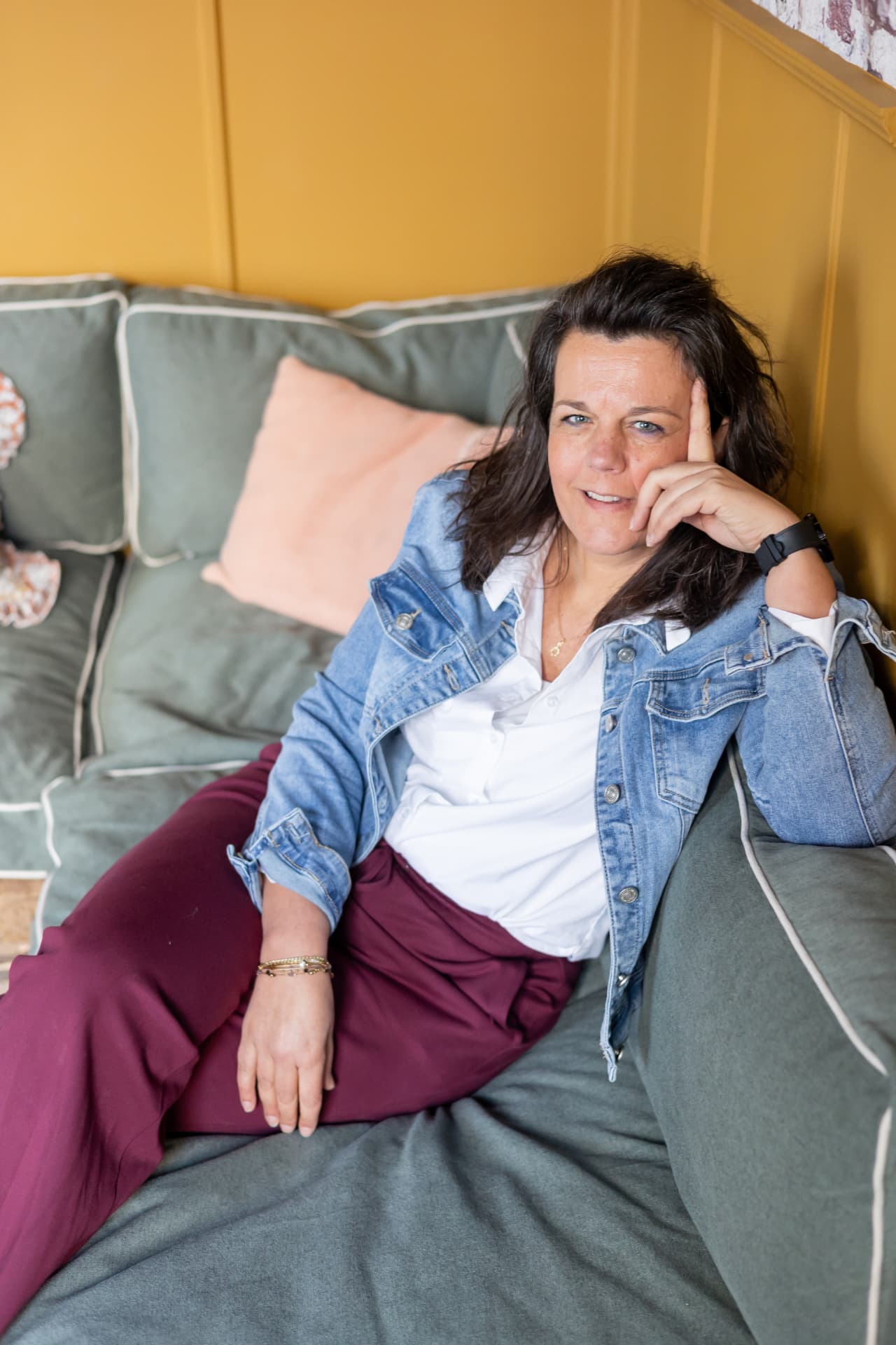 Mathilda van den Hof ontspannen zittend op een bank