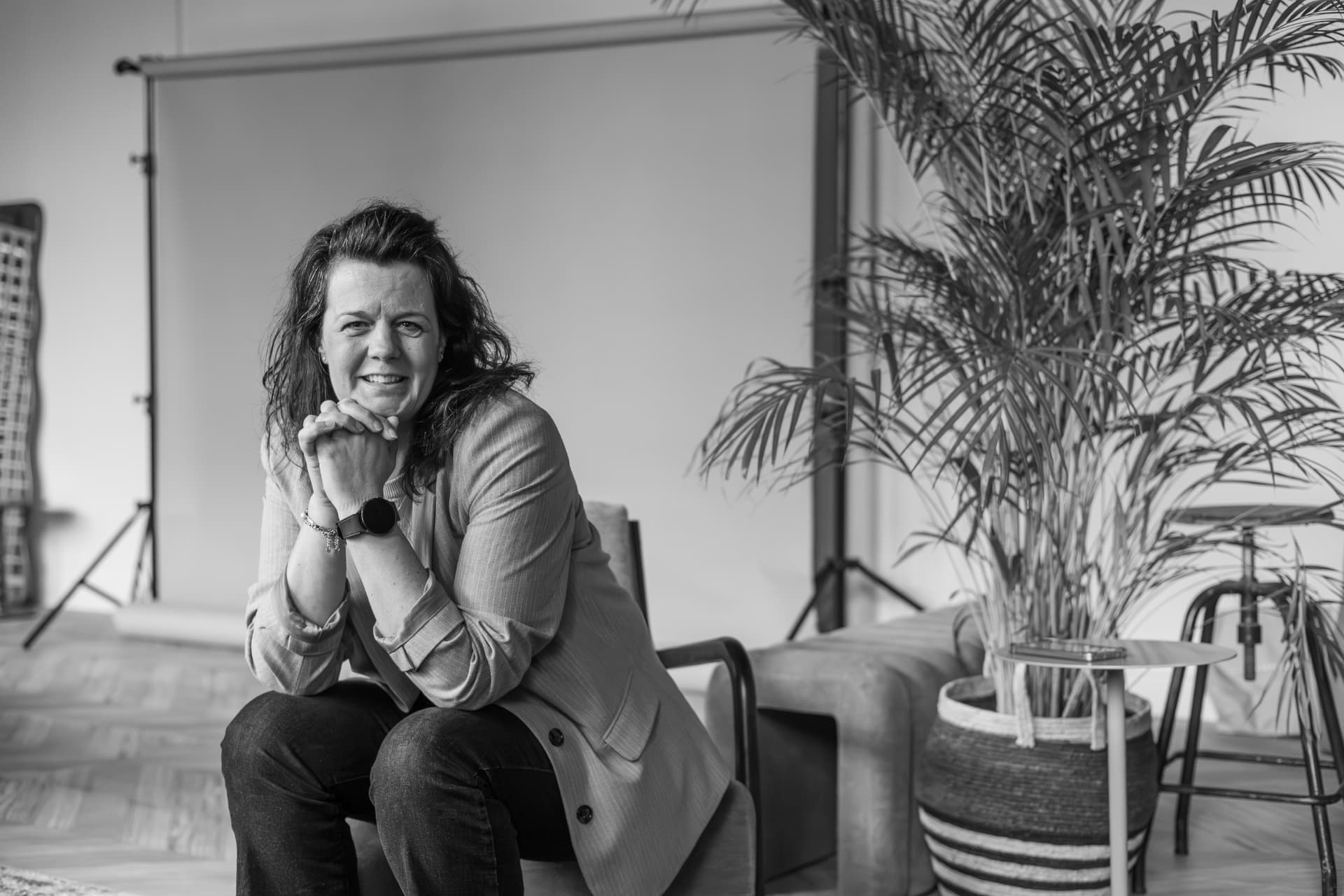Zwart-witportret van Mathilda van den Hof, zittend met haar handen onder haar kin